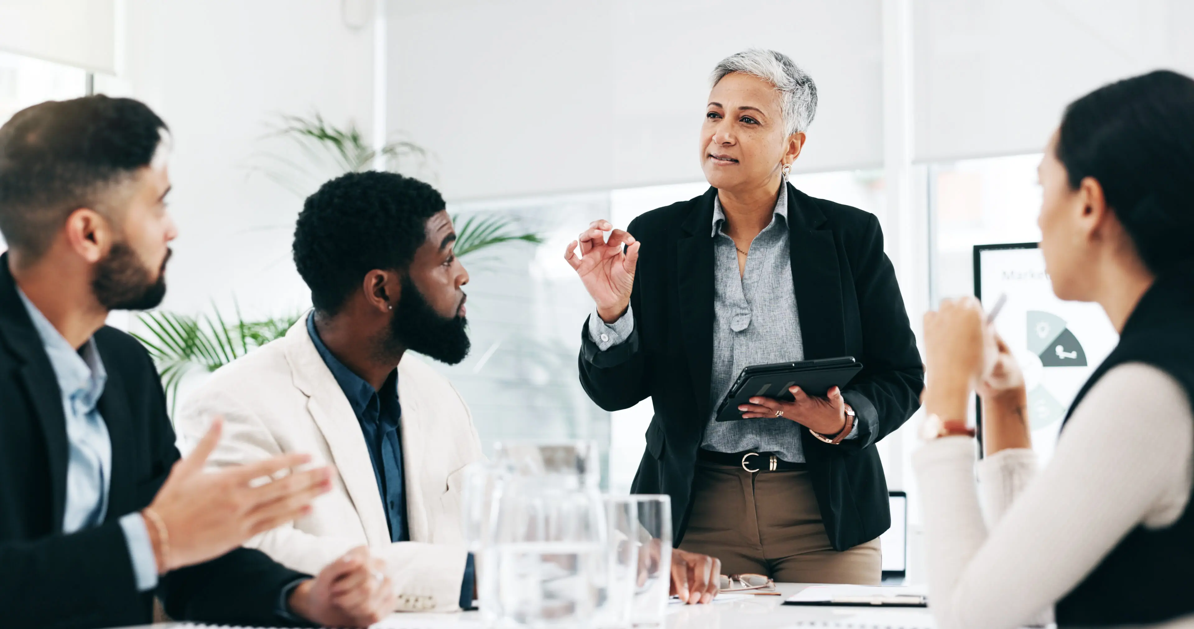 Presentation, coaching and meeting with business woman and tablet for research, training and project management. Idea, strategy and data analysis with ceo and people in office for brainstorming chart Blessed Team Consulting LLC